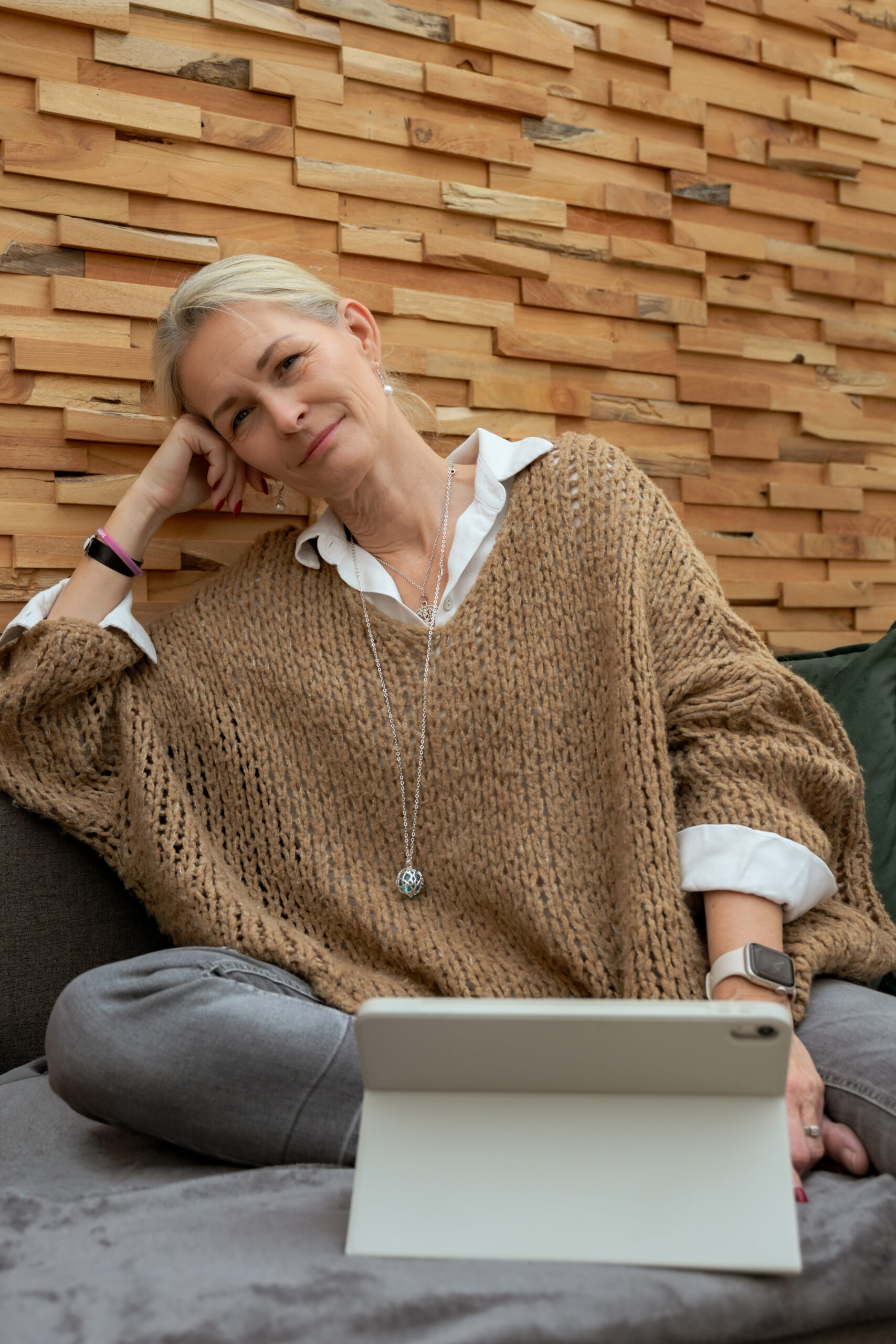 Auf dem Bild sieht man Marion Lang. Man sieht sie links von der Seite. Sie trägt keck einen weißen Hut auf dem Kopf den sie mit ihrer rechten Hand antippt. Ihre blonden Haare fallen locker nach hinten weg. Sie trägt einen rosa weiß gemusterten Pullover und im Hintergrund sieht man den Himmel.